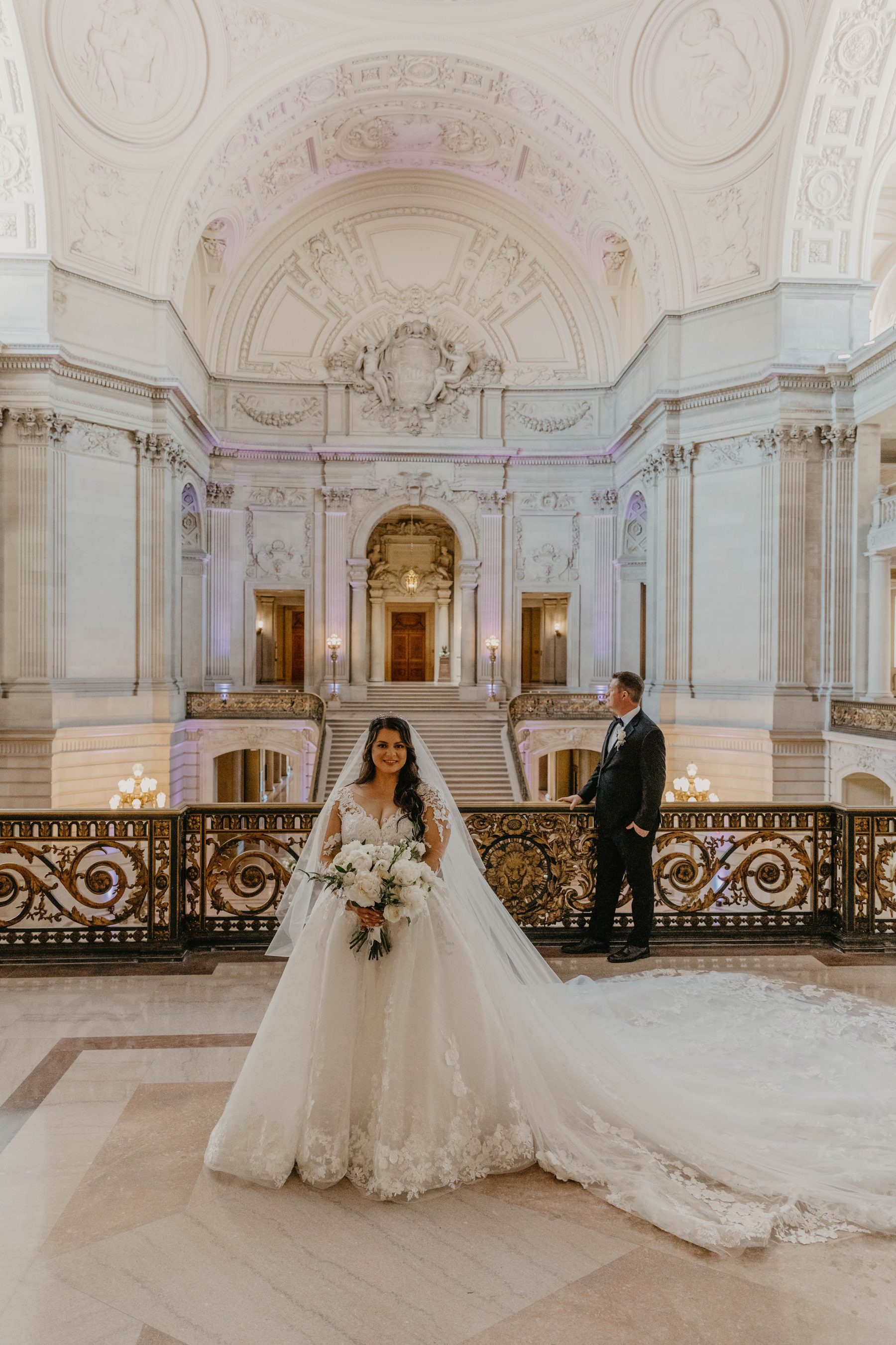 Bride in a cathedral-length veil with the groom in San Francisco City Hall’s rotunda — Dejeu Crew wedding photography