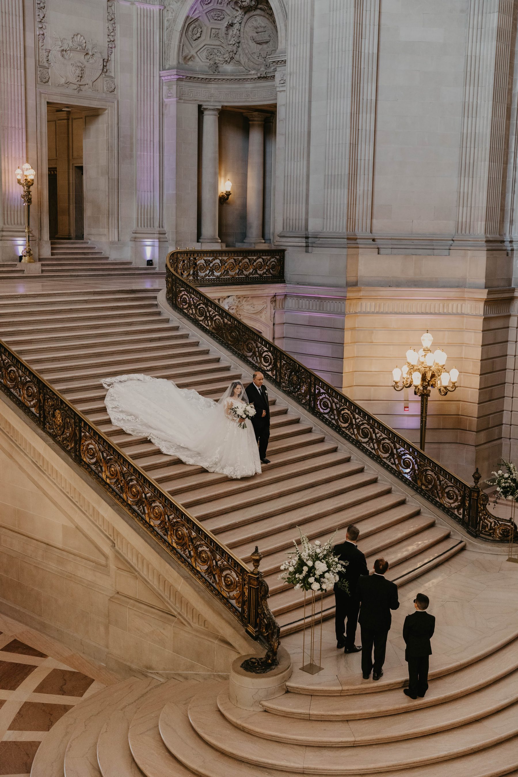 Bride’s long veil flowing down the grand staircase at San Francisco City Hall — Dejeu Crew wedding photography