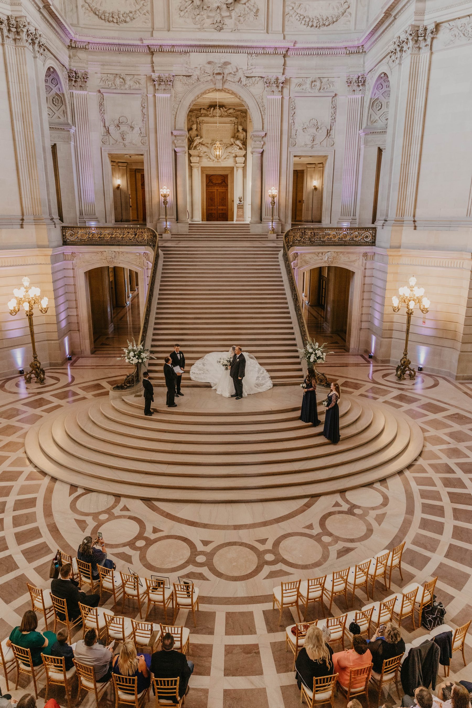 Overhead view of a wedding ceremony at the foot of the grand staircase in San Francisco City Hall’s rotunda — Dejeu Crew wedding photography