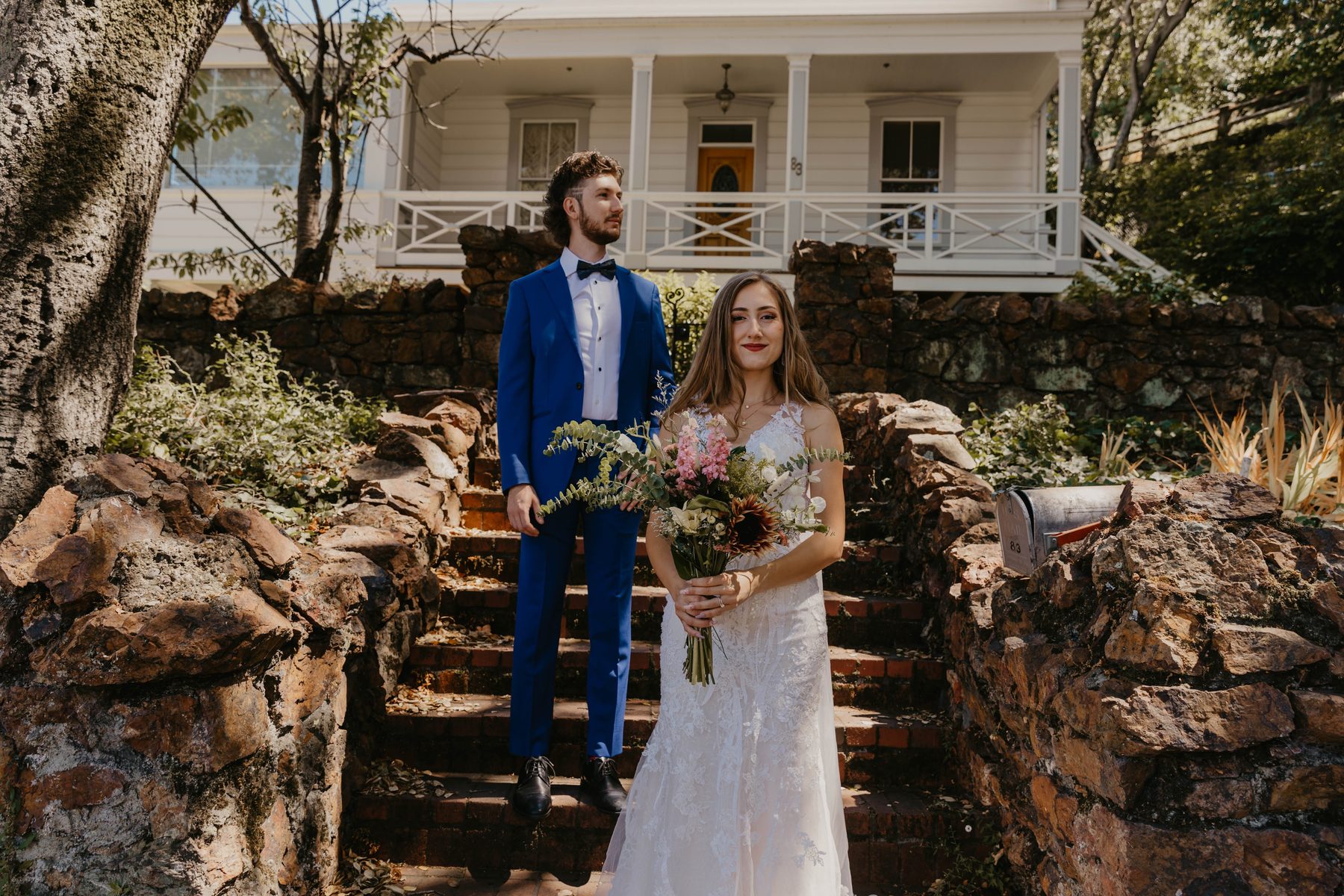 Bride and groom on garden steps in front of a historic white house — Dejeu Crew wedding photography