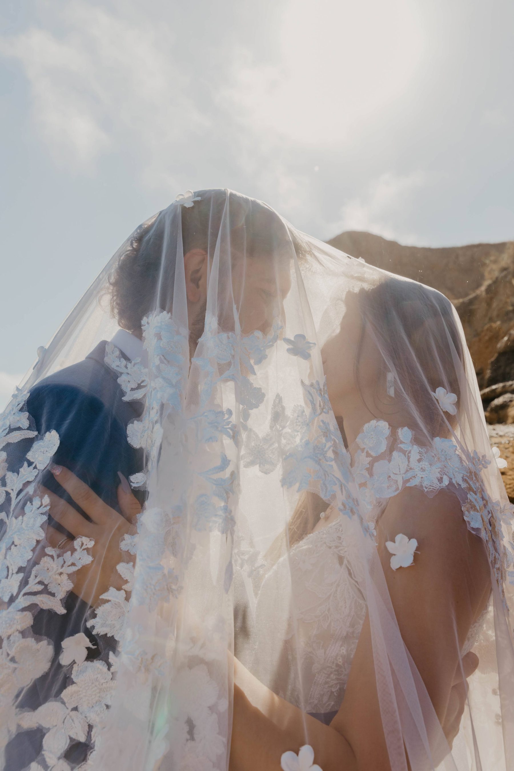 Bride and groom close together beneath a sunlit lace veil — Dejeu Crew wedding photography