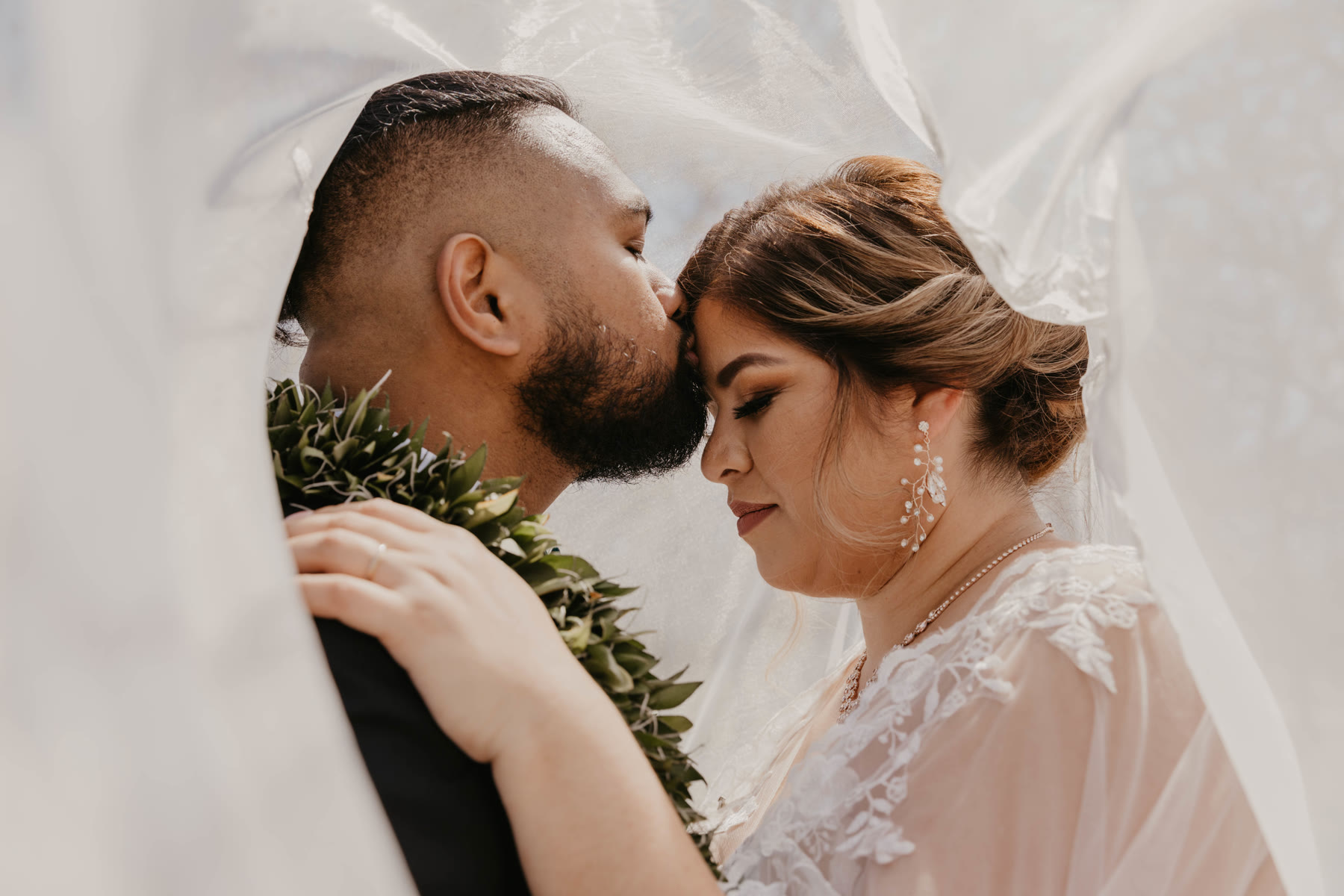 Groom kissing the bride’s forehead through her wedding veil — Dejeu Crew wedding photography